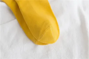 Close-up shot of yellow cotton socks, showing soft knit texture and neat toe seam details.