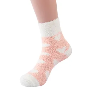 Cozy fuzzy winter fleece socks detail, soft coral velvet home sleep socks with pink heart pattern.