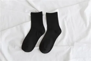 Close-up detail shot of classic black crew socks on white background, daily wear.