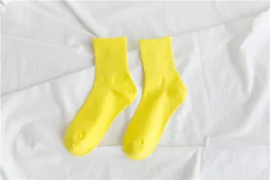 Bright neon yellow cotton mid-tube socks detail shot, soft fabric texture close-up view.