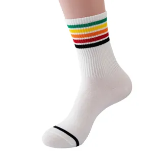 White mid-tube athletic socks featuring colorful retro stripes at the upper cuff.