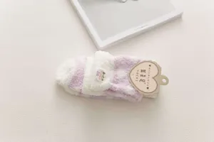 Fuzzy coral fleece warm winter socks close-up, soft touch striped floor sock detail view.