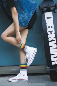 Women's striped mid-tube socks paired with white canvas shoes for a stylish street look.