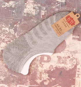 Vue détaillée de chaussettes basses grises pour hommes avec semelle éponge et étiquette.