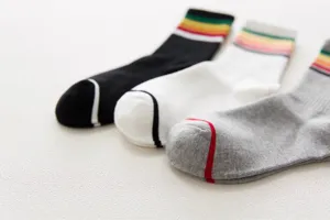 Close-up detail view of women's colorful striped mid-calf socks with contrast toes.
