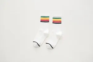 Detailed view of white mid-calf athletic socks featuring retro multi-color striped cuffs.