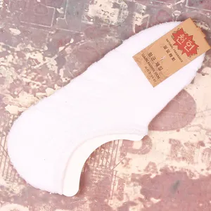 Vue de detail de chaussettes bateau invisibles coupe basse blanches, tissu eponge confortable.