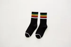 Detail view of women's black crew socks featuring colorful rainbow stripes and toe lines.