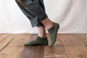 Detailed view of thick olive green sports low cut socks with soft towel bottom for hiking.