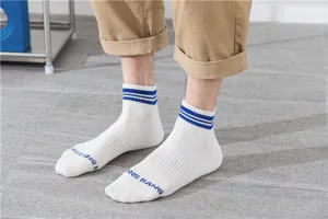 Nahaufnahme Detail von weißen Herren Kurzsportocken mit blauen Streifen und Zehenlogo.