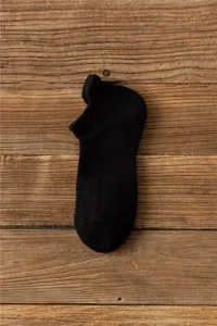 Black athletic crew socks detail shot showing thick towel loop cushion sole for running outdoor hiking.