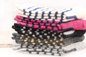 Nahaufnahme gefalteter Winter-Wollkaschmirsocken mit bunten Streifen und gemütlichem Karomuster.
