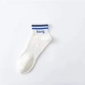 Nahaufnahme Detail von weißen Baumwoll-Sneakersocken mit blauen Streifen und Stickerei.