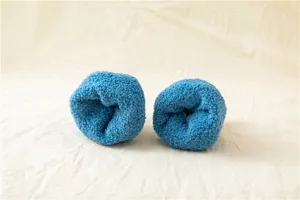 Dettaglio in primo piano di calze morbide blu peluche arrotolate su un bel tessuto.