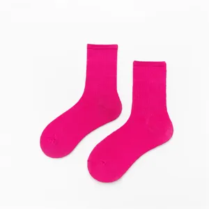 Gros plan sur des chaussettes en coton côtelé magenta vif, texture de tricot confortable.