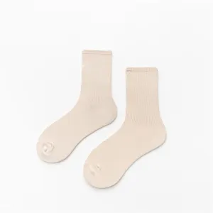 Vue détaillée de chaussettes unies beige pour femmes à côtes, texture en coton doux et confortable.