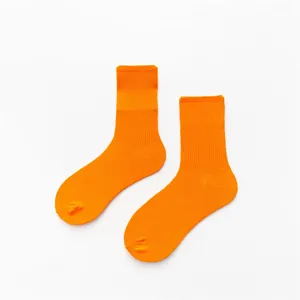 Gros plan de chaussettes côtelées orange vif, tissu en coton doux texturé detail.