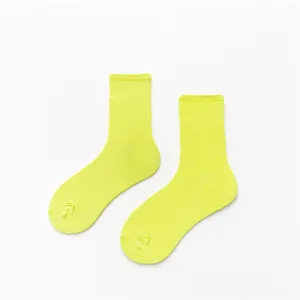 Détail de chaussettes mi-hautes jaune néon, gros plan chaussettes de sport coton.