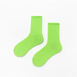 Vue détaillée des chaussettes en coton vert vif, montrant le bord côtelé et le tissu.