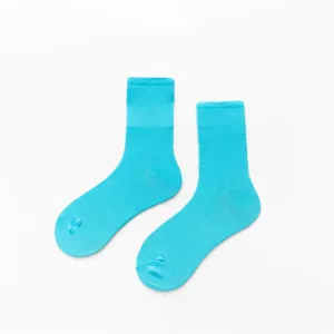 Gros plan de chaussettes hautes en coton cyan vif, avec bord côtelé net et texture douce.