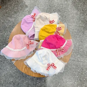 Closeup of cute kids bucket hat details, featuring lace ruffle, pearls and plaid bow design.