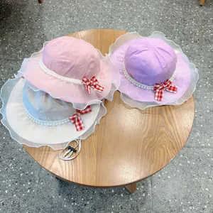 Detailed view of cute kids bucket hat with lace mesh, pearl trim and sweet checkered bow.