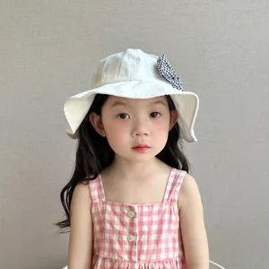Cute baby toddler girl sun hat white fisherman bucket hat with houndstooth bow detail.