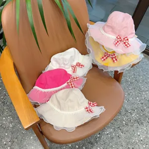 Kids bucket hat with delicate lace brim, cute pearl trimming and bowknot. Detailed view.