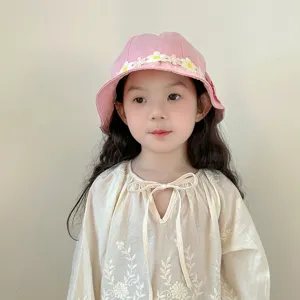 Cute pink kids bucket hat with floral lace trim, soft cotton fabric, sun protection detail.