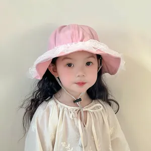 Detailed view of cute pink baby bucket hat with white lace trim and adjustable sun protection.