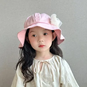 Close-up detail of cute pink baby bucket hat featuring delicate lace flower, soft sun hat.