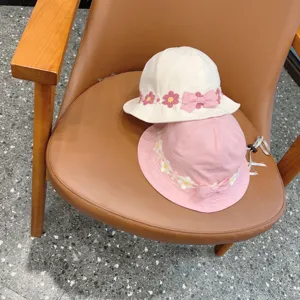 Cute floral embroidered bucket hat detail shot, sweet bow design, ideal for lovely kids.