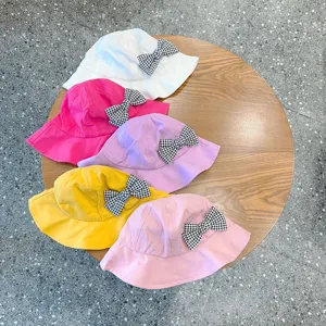 Detailed view of colorful kids bucket hats featuring cute houndstooth bow accents.