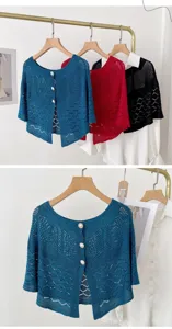 Close-up details of hollow knitted shawl with elegant pearl buttons in vibrant colors.