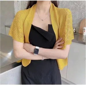 Detailed shot of women's yellow knitted summer sun protection shawl with hollow out design.