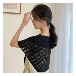 Detail view of black knitted hollow-out shawl, perfect for summer sun protection and layering.