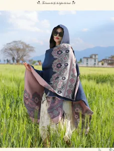 Close-up of ethnic floral hooded cloak shawl, detailed tassel hem and thick warm fabric.