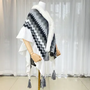 Detailed view of the knitted chevron pattern, soft faux fur collar, and fringe hem on cape.