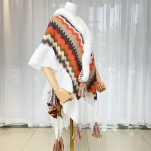 Close-up of the knitted zigzag chevron cape with cozy faux fur collar and chic tassel hem.
