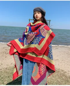 Detailed view of the ethnic style knitted cloak worn outdoors by the seaside, cozy woolen material.