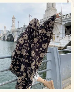 Detail shot of retro floral hooded poncho cape showing daisy pattern and textured border trim.