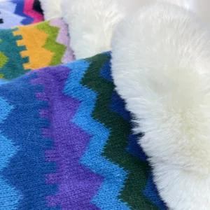 Detailed close-up of colorful knitted striped shawl featuring a fluffy white faux fur collar.