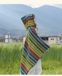 Colorful striped hooded cape detail, ethnic style poncho shawl in natural outdoor field view.