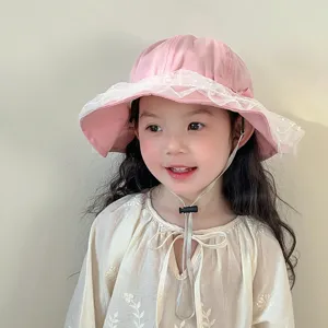 Cute pink baby bucket hat with delicate white lace trim and adjustable strap for toddler girls.