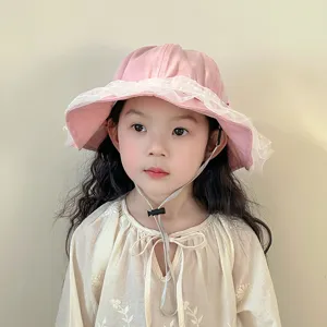 Cute pink baby bucket hat with white lace trim and adjustable strap, perfect for sunny days.