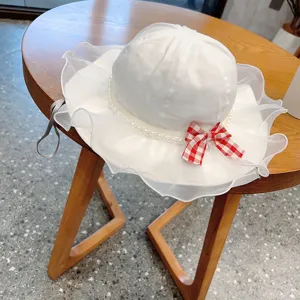 Cute baby white fisherman hat with pearl trim and red bow for spring and summer outdoor.