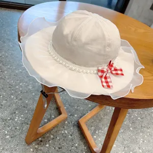 Cute baby sun hat with mesh ruffle, pearl trim, and red plaid bow for toddler girls summer.