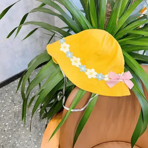 Cute yellow children bucket hat with floral lace trim and sweet pink bow for baby girls.