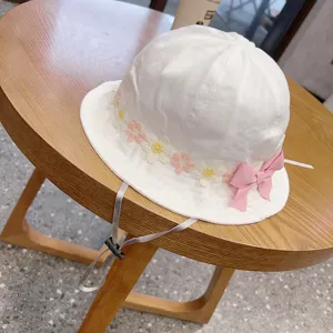 Cute baby bucket hat with floral embroidery, pink bow, and adjustable strap for kids sun protection.