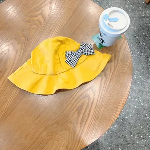Cute yellow baby bucket hat with black and white houndstooth bow for spring daily wear.